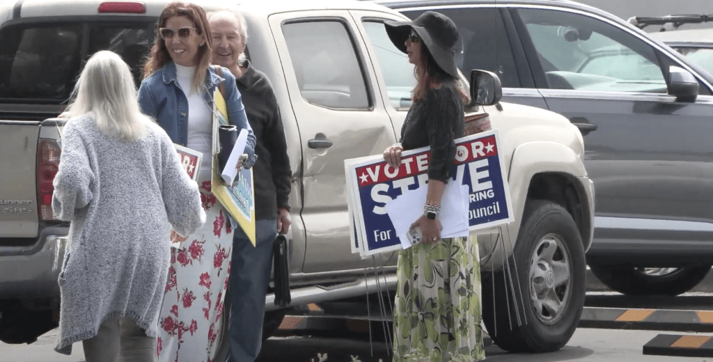 Steve Uhring talks with Malibu residents in the Point Dume Clubhouse parking lot Sept. 22. Residents are holding the signs for candidates Steve Uhring and Bruce Silverstein.